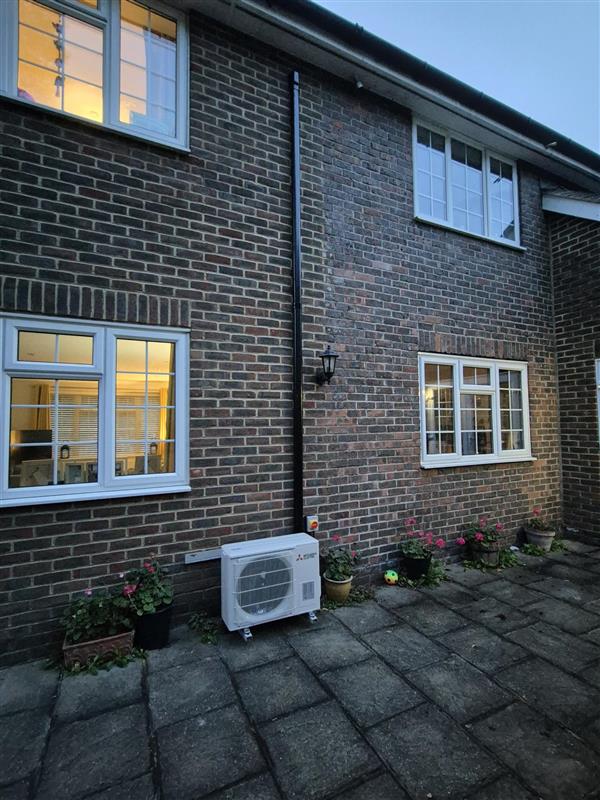 Mitsubishi Classic wall-mounted air conditioning indoor unit installed high on a bedroom wall.